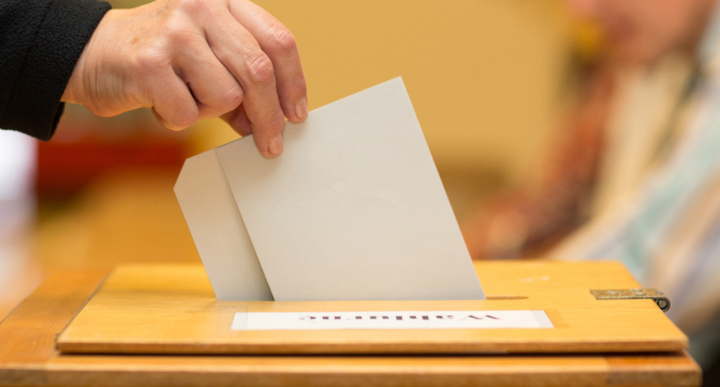 Stimmzettel in Wahlurne geworfen. Quelle: Fotolia