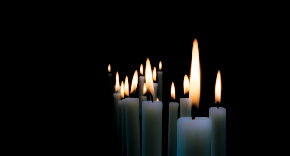 Brennende Kerzen vor schwarzem Hintergrund. Quelle: Fotolia