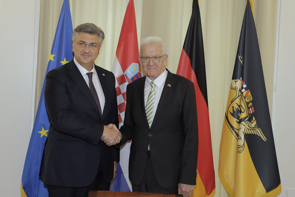 Besuch Kretschmann empfängt kroatischen Premierminister Ministerpräsident Winfried Kretschmann (rechts) und der kroatische Premierminister Andrej Plenković (links) stehen vor Fahnen und geben sich dabei die Hand.