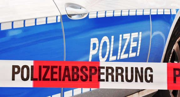 Polizeiabsperrung vor einem Streifenwagen.