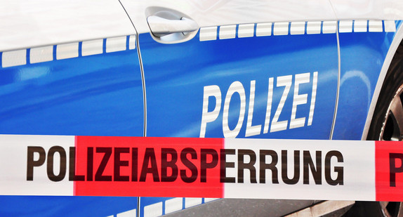 Polizeiabsperrung vor einem Streifenwagen.