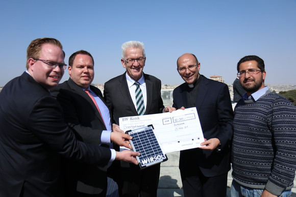 DELEGATIONSREISE Reise nach Israel und in die Palästinensischen Gebiete Ministerpräsident Winfried Kretschmann (M.) übergibt Pfarrer Mitri Raheb (2.v.r.) beim Besuch des Dar al-Kalima-College in Bethlehem einen Scheck zum Ausbau der Solaranlage des Colleges