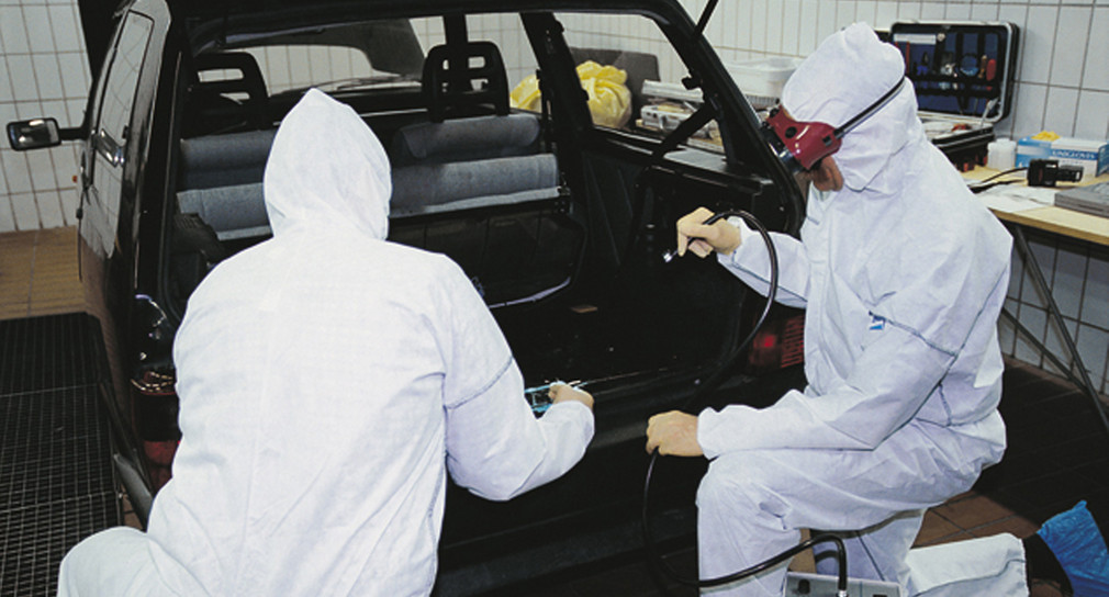 Zwei Kriminaltechniker untersuchen ein Auto auf Spuren. 