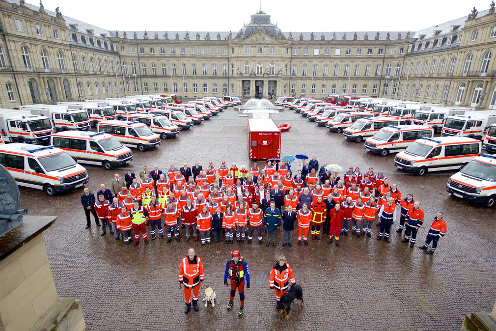 Vertreterinnen und Vertreter der Hilfsorganisationen vor den neuen Fahrzeugen im Ehrenhof des Neuen Schlosses
