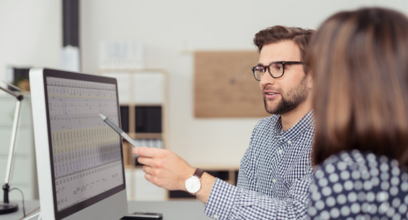 Ein Mitarbeiter erklärt seiner Kollegin etwas am PC. Quelle: Fotolia