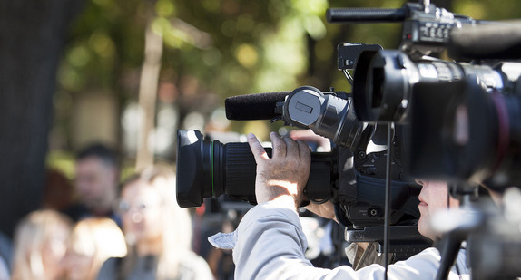 Fernsehkameras sowie Journalistinnen und Journalisten bei einer Pressekonferenz im Freien.
