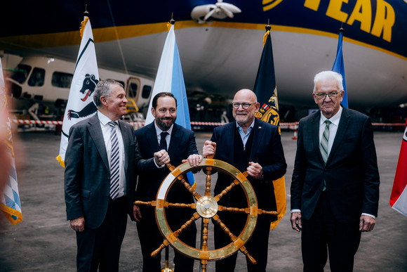 Symbolische Steuerradübergabe im Zeppelin-Hangar Friedrichshafen (von links nach rechts): Ernst Stocker, Regierungsrat des Kantons Zürich, Europastaatssekretär Florian Haßler, Verkehrsminister Winfried Hermann und Ministerpräsident Winfried Kretschmann