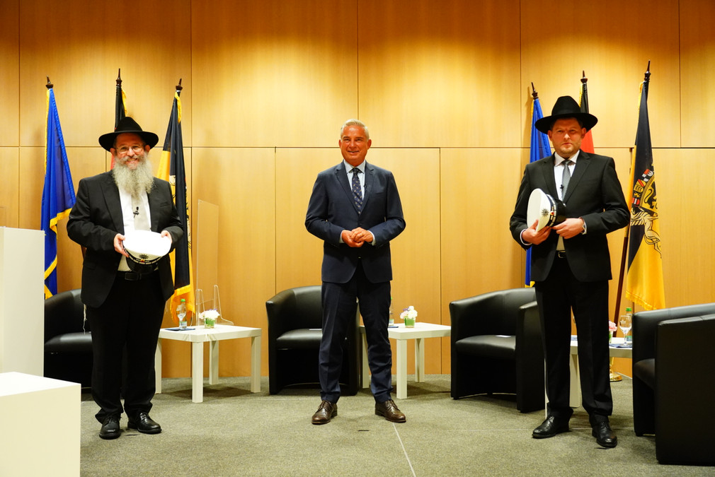 Minister Strobl und die beiden ersten Polizeirabbiner der Polizei Baden-Württemberg stehen für ein Foto zusammen.