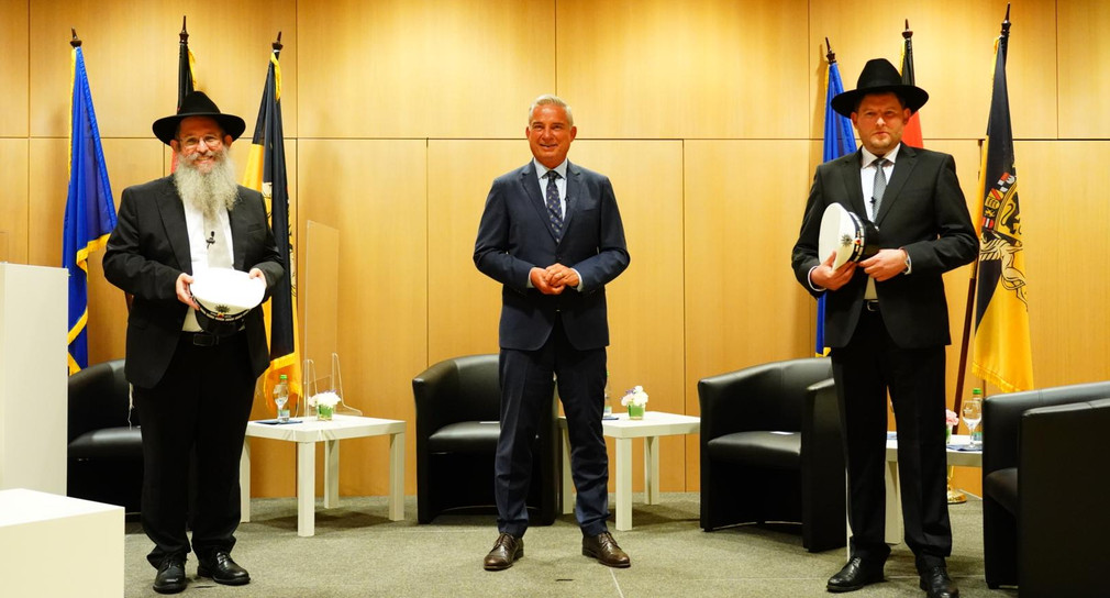 Minister Strobl und die beiden ersten Polizeirabbiner der Polizei Baden-Württemberg stehen für ein Foto zusammen.