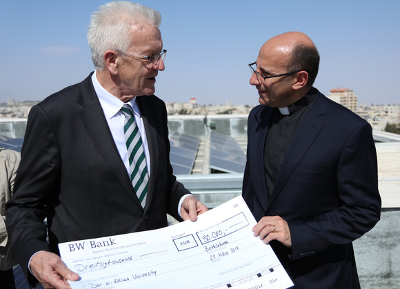 DELEGATIONSREISE Reise nach Israel und in die Palästinensischen Gebiete Ministerpräsident Winfried Kretschmann (l.) übergibt Pfarrer Mitri Raheb (r.) beim Besuch des Dar al-Kalima College in Bethlehem einen Scheck zum Ausbau der Solaranlage des Colleges