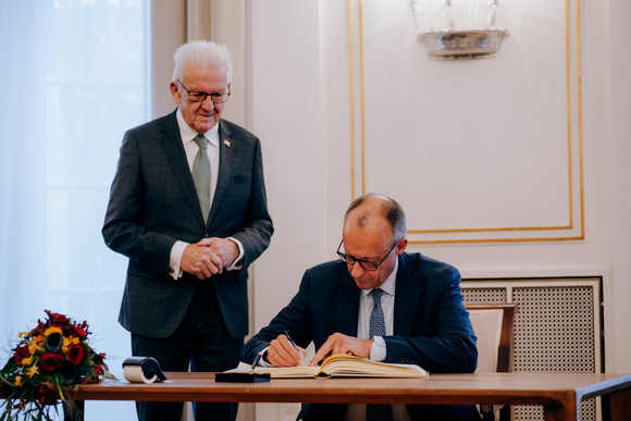 Antrittsbesuch  Bundeskanzler Friedrich Merz besucht Baden-Württemberg Bundeskanzler Friedrich Merz (rechts) beim Eintrag in das Gästebuch des Landes, daneben steht Ministerpräsident Winfried Kretschmann (links)