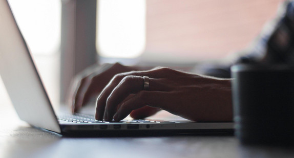 Eine Person schreibt auf der tastatur eines Laptops