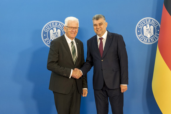 Europa Kretschmann auf Delegationsreise im Donauraum Ministerpräsident Winfried Kretschmann (links) und Rumäniens Premierminister Ion-Marcel Ciolacu (rechts) geben sich die Hand.