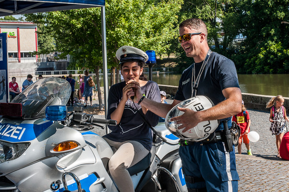 Ein Mädchen testet mit einem Polizisten ein Polizeimotorrad. Quelle: Polizei Baden-Württemberg