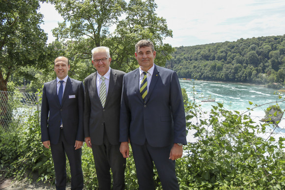 Delegationsreise Kretschmann besucht die Schweiz Christian Amsler (r.), Regierungspräsident des Kantons Schaffhausen, Ministerpräsident Winfried Kretschmann (M.) und Peter Schneck (l.), CEO Trapeze Switzerland, am Rheinfall in Schaffhausen