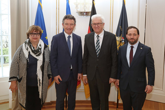 Antrittsbesuch Kretschmann empfängt Präsidenten der Région Grand Est von links nach rechts: Brigitte Torloting, Vizepräsidentin der Région Grand Est, Franck Leroy, Präsident der Région Grand Est, Ministerpräsident Winfried Kretschmann und Staatssekretär Florian Hassler stehen in der Villa Reitzenstein vor Fahnen.