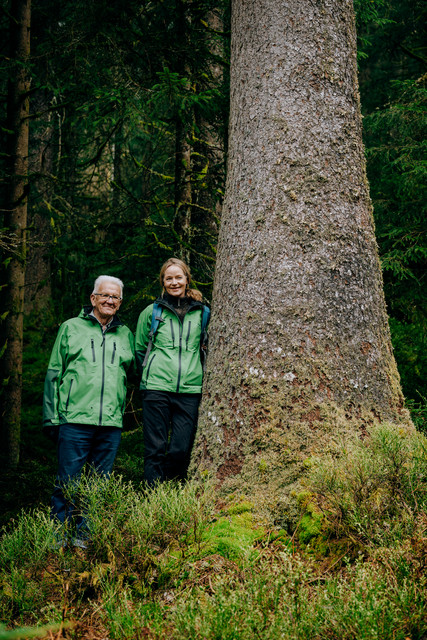 Ministerpräsident Winfried Kretschmann (links) und Umweltministerin Thekla Walker (rechts) stehen neben einer Säulenfichte, die ihr gewidmet wurde.