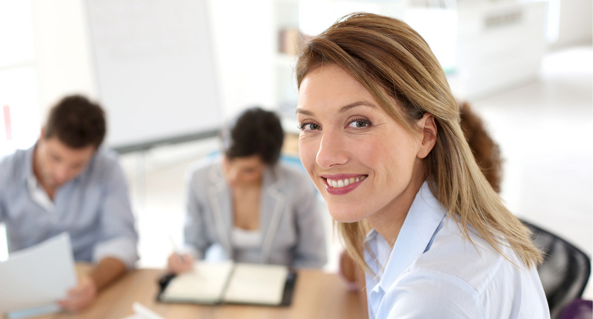 Geschäftsfrau vor Mitarbeitern. Quelle: Fotolia.