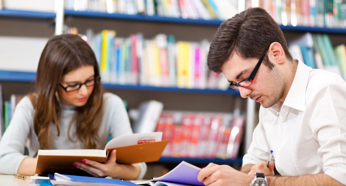 Zwei Studenten beim Lernen in der Bibliothek. Quelle: Fotolia.