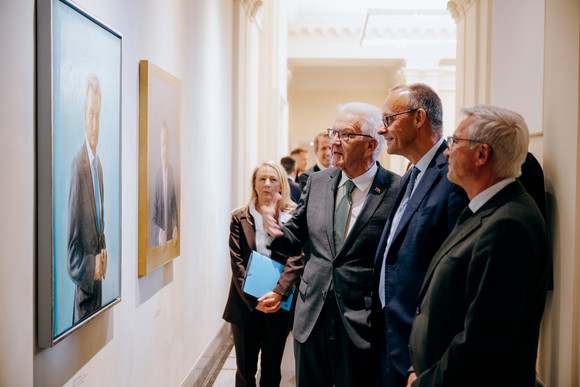 Antrittsbesuch  Bundeskanzler Friedrich Merz besucht Baden-Württemberg von links nach rechts: Ministerpräsident Winfried Kretschmann, Bundeskanzler Friedrich Merz und Innenminister Thomas Strobl betrachten die Porträts der früheren Ministerpräsidenten von Baden-Württemberg