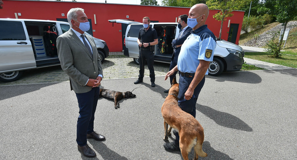 Innenminister Thomas Strobl übergibt einem Polizeibeamten die Bodycam