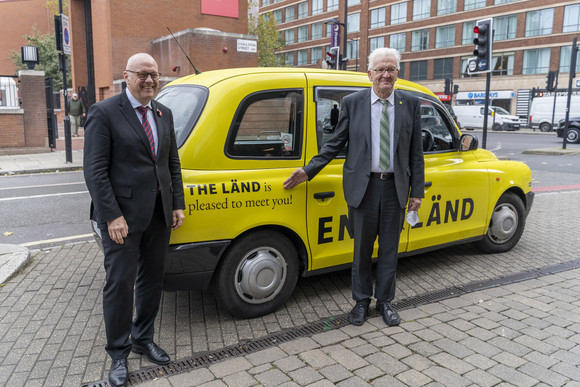 Auslandsreise Delegationsreise nach Schottland und England Andreas Michaelis (links), Botschafter der Bundesrepublik Deutschland im Vereinigten Königreich, und Ministerpräsident Winfried Kretschmann (rechts) vor einem Londoner Taxi im Design der neuen „THE LÄND“-Kampagne