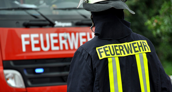 Feuerwehrmann vor einem Feuerwehrfahrzeug. Quelle: Fotolia