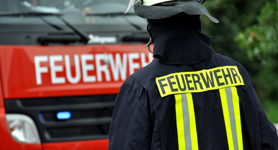 Feuerwehrmann vor einem Feuerwehrfahrzeug. Quelle: Fotolia