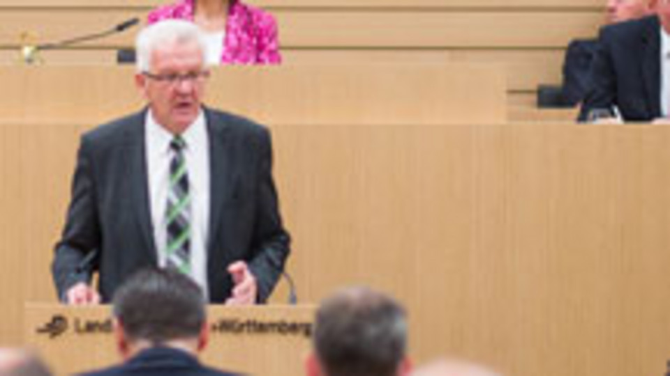 Ministerpräsident Kretschmann spricht am Rednerpult im Landtag von Baden-Württemberg (Bild: © dpa).