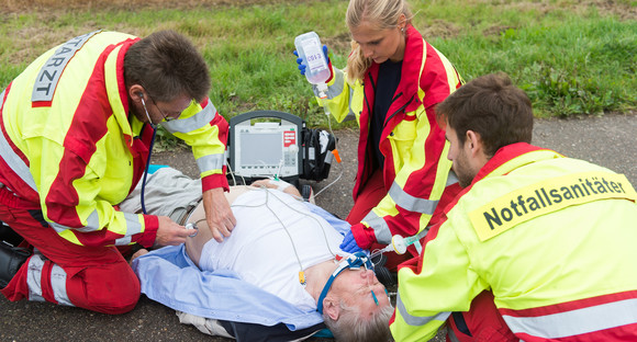 Ein Notarzt und zwei Notfallsanitäter kümmen sich um einen verletzten Mann