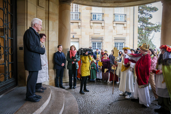 Ministerpräsident Winfried Kretschmann und seine Ehefrau Gerlinde (links) begrüßen die Sternsingerinnen und Sternsingern am Eingang der Villa Reitzenstein. 