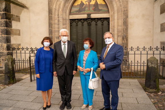 Reise Kretschmann besucht Sachsen-Anhalt v.l.n.r: Gabriele Haseloff, Ministerpräsident Winfried Kretschmann mit Ehefrau Gerlinde und Reiner Haseloff, Ministerpräsident von Sachsen-Anhalt, vor der Thesentür von Martin Luther am Eingang zur Schlosskirche in Wittenberg (Bild: Staatsministerium Baden-Württemberg)