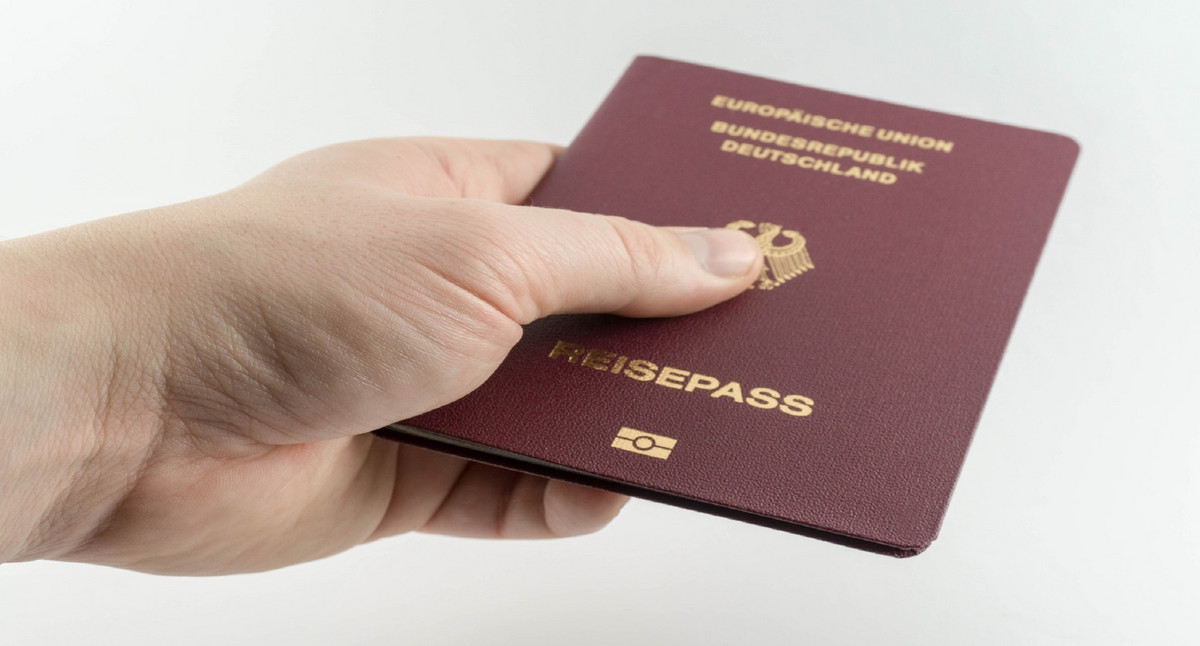 Eine Hand mit einem Reisepass. Quelle: Fotolia