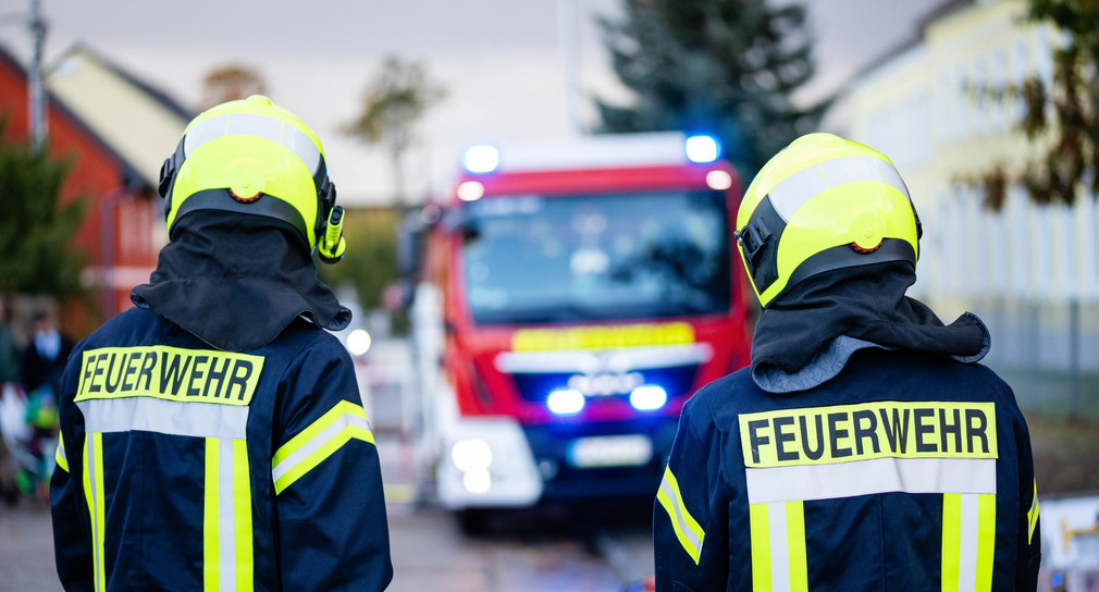 Zwei Feuerwehrleute vor einem Einsatzfahrzeug