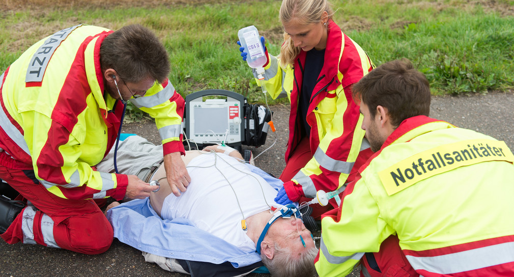 Ein Notarzt und zwei Notfallsanitäter kümmen sich um einen verletzten Mann