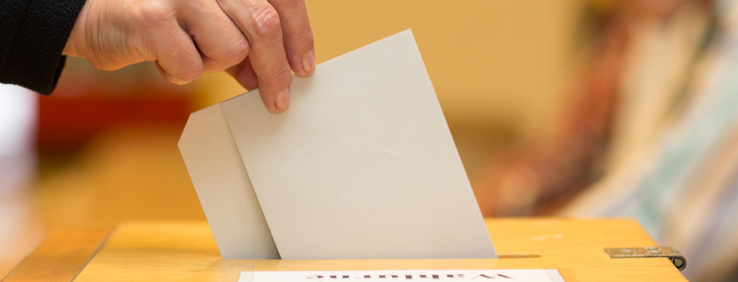 Stimmzettel in Wahlurne geworfen. Quelle: Fotolia