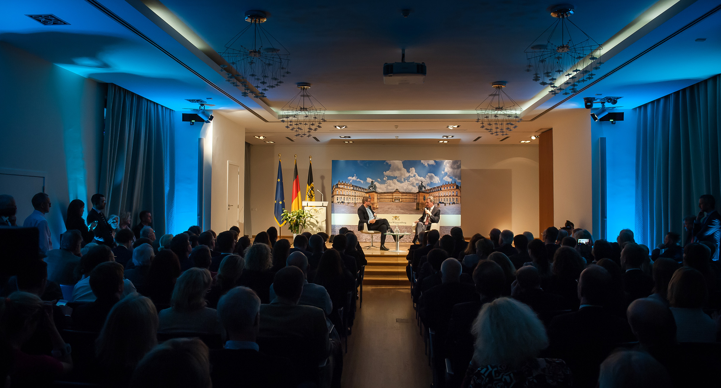 Veranstaltung im Saal mit beleuchteter B&uuml;hne